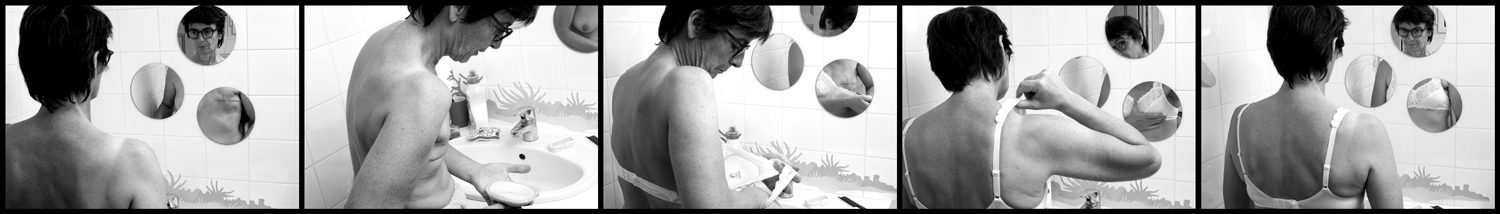 photo noir et blanc en cinq images d'une femme dans une salle de bain face à trois petits miroirs ronds renvoyant son image en train de mettre une prothèse de sein dans son soutien gorge le buste vu de dos les miroirs font voir fractionné le déroulement