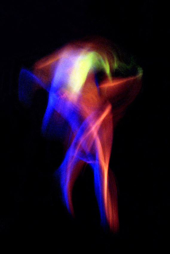 photos couleurs saturées homme en mouvement laissant apparaitre des traces lumineuses bleues rouges jaunes et vertes sur fond noir